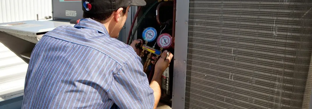 HVAC technician servicing a condenser unit in Noble