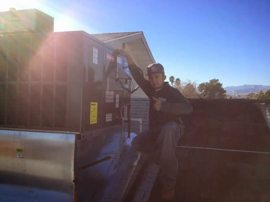 HVAC technician performing Boiler Repair on a rooftop unit in Noble